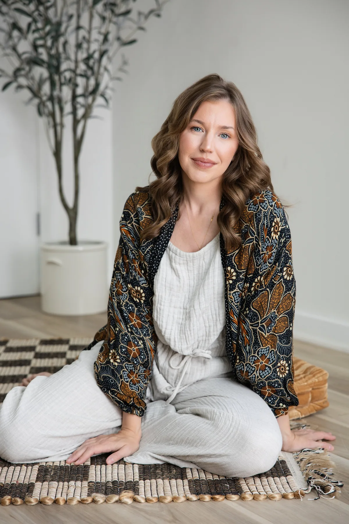 Sarah Bland, who leads the midday meditation in Glen Carbon, sitting on a woven rug in a floral batik jacket